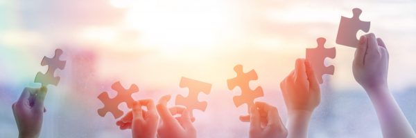 Hands,Of,Children,Students,Holding,Pieces,Of,Jigsaw,Together,As