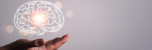 Man,Hand,Holding,Brain,Illustration,Against,Gray,Wall,Background.,Concept