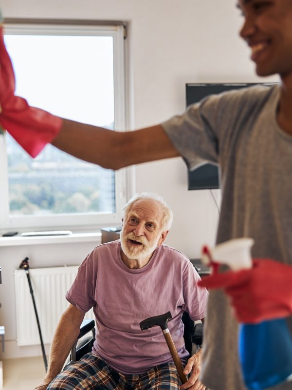Volunteer helping a disabled person clean his home
